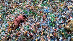 un-trabajador-descansa-sobre-montanas-de-plasticos-para-reciclar-reuters